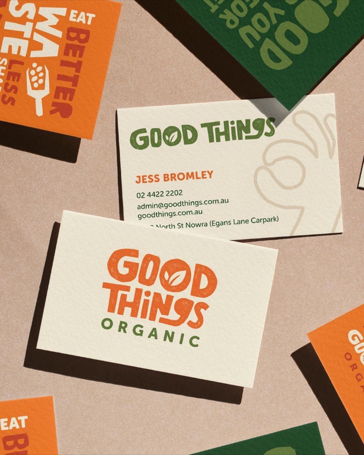 Organic grocery identity in orange and forest green, chunky hand-drawn lettering with a leaf counter, printed on uncoated cream stock.