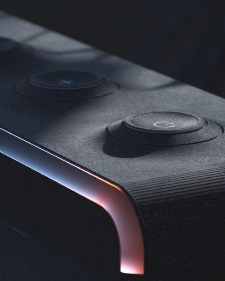 Matte black hardware detail where a chrome edge catches a warm orange-to-cool gradient, recessed rubber buttons with etched icons.